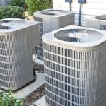 Gray air conditioning compressors in a neat row, highlighting HVAC efficiency by Tiger Temperature.
